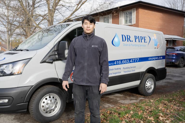 Dr. Pipe technician in front of a service van for rough-in plumbing service in Toronto